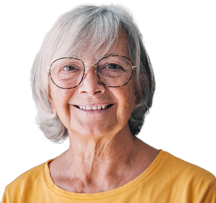 An elderly white woman and glasses smiles in a yellow shirt